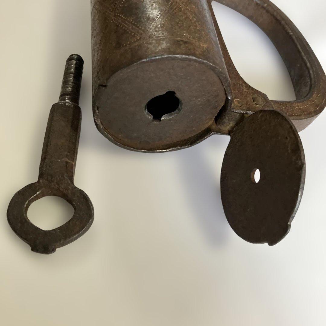 アンティークな鉄製スクリュー式円筒型南京錠（表面には点描幾何学模様）