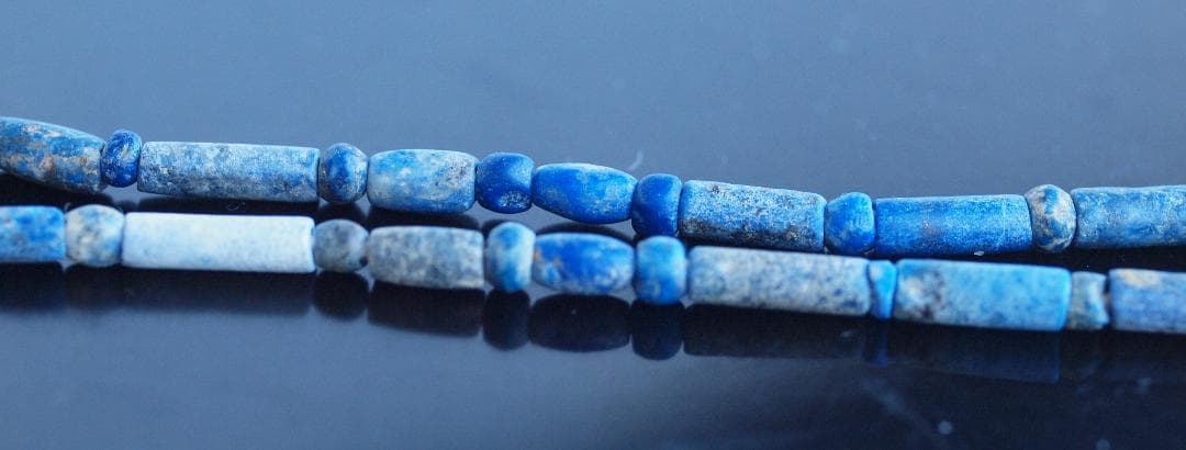 古代濃紺ラピスの管玉や丸玉をほぼ左右対称に編み、トップに斧型や多面体、80個の連