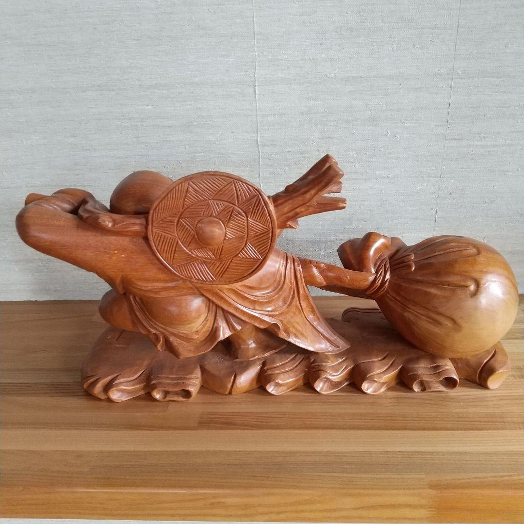 木製布袋の置物で一枚木彫りの高さ25cm長さ52cm幅15cm重さは約５キロです